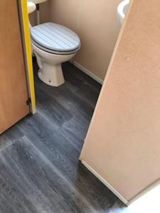 uma casa de banho com WC e piso em madeira em TP52 em Skegness