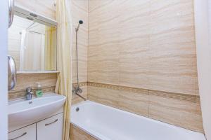 y baño con bañera blanca, lavamanos y bañera tubermott. en Apartament Nazarbaeva 119, en Almaty 16 fotos más