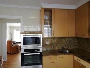 a kitchen with a stove and a microwave at Amplio y soleado Alquilo apartamento entero de 3 hab 5 pax in Zarautz