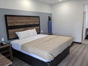 um quarto com uma cama grande e uma cabeceira em madeira em Captain Suites em Baytown