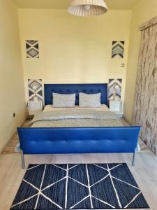 a large blue bed in a bedroom with a blue bedspread at Stepin in Kiskunfélegyháza