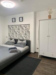 a bedroom with a bed and a white cabinet at Appartement W@llstreet in Nordhausen