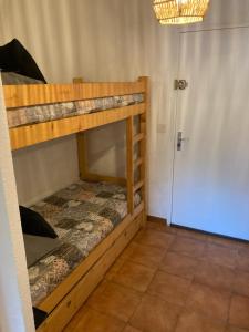 a room with two bunk beds and a door at studio cabine. Terrasse in Le Lavandou