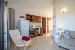 a kitchen with a white refrigerator and a white chair at Irina Beach Apartment in San Miguel de Abona