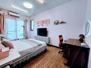 a bedroom with a bed and a desk and a computer at 金廈之星 in Jinning