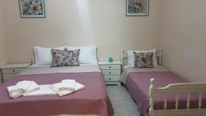 duas camas num quarto com lençóis cor-de-rosa em Evelyn Home em Limenas
