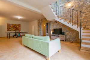 un soggiorno con divano e una scala di Località Poggio Capriolo Il Casale dei Ciliegi a Baschi