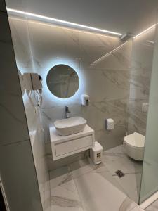 biała łazienka z umywalką i toaletą w obiekcie Stonevilla Buta w mieście Himara
