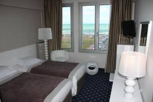 a hotel room with a bed and a window at Hotel Aguado in Dieppe