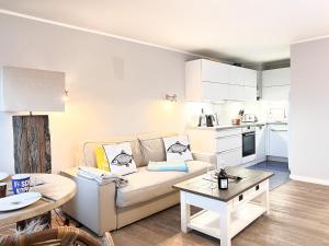 uma sala de estar com um sofá e uma mesa em Sylter Residenz App 43 mit Meerblick em Westerland