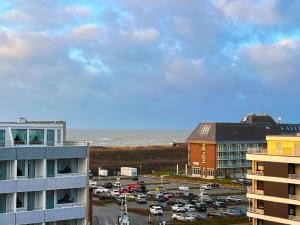 a parking lot next to the ocean with cars parked at Sylter Residenz App 43 mit Meerblick in Westerland