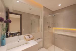 uma casa de banho com um lavatório e uma cabina de duche em vidro. em HY Apartments & Hotels no Recife