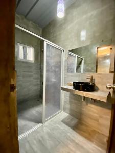 a bathroom with a glass shower and a sink at Hai Inn in Dumaguete