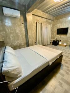 uma cama grande num quarto com televisão em Hai Inn em Dumaguete