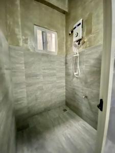 uma casa de banho com um chuveiro e um telefone na parede em Hai Inn em Dumaguete