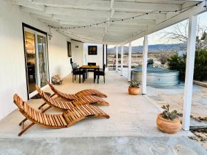 a patio with chairs and a table on a house at Ravens Nest Ranch, Fire pit , Views, Near JT Park! in Joshua Tree
