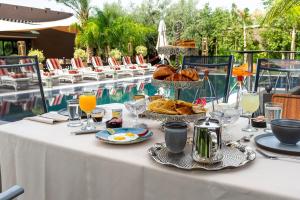 a table with food and drinks next to a pool at The Lemonary Marrakech in Marrakech