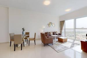 a living room with a table and a dining room at Key View - Carson A, DAMAC Hills in Dubai Marina