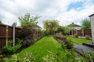 a garden with a lawn and a fence at Strawberry Fields House - Air Host & Stay - 3 Bedroom in Liverpool
