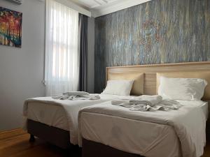 イスタンブールにあるJasmine Apart & Boutique Hotelの壁に絵画が飾られたベッドルーム1室(ベッド2台付)