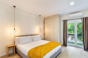 um quarto com uma cama e uma grande janela em Sé Apartamentos - Liberdade 546 Apartments em Braga