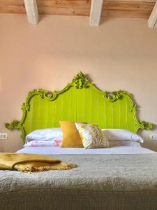 a bed with a green headboard in a bedroom at Effimera - Relaxing Retreat in Citta' Sant'Angelo