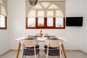 une salle à manger avec une table et des chaises blanches dans l'établissement Orkos Naxian Wave 3, à Mikri Vigla