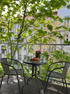 a table with two chairs and a bowl of fruit on a balcony at Złote Apartamenty 36 in Legnica
