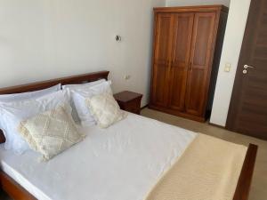 a bedroom with a white bed with white pillows at Port Balchik apartment in Balchik