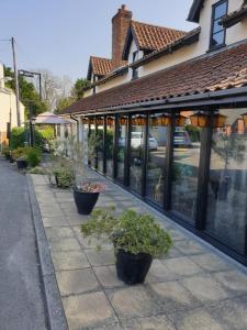 a sidewalk with potted plants in front of a building at The Crown Lodge & Restaurant in Dogdyke