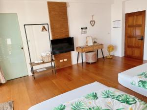 a living room with a television and a wooden floor at 木子家民宿 in Magong