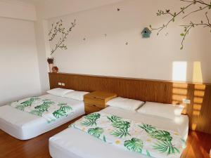 two beds in a room with a wall at 木子家民宿 in Magong