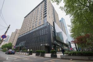 a tall building on a city street with buildings at Nanjing Kaibin Apartment - Aishang Shopping Mall in Nanjing