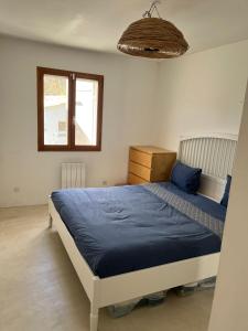 Schlafzimmer mit einem Bett mit blauer Bettwäsche und einem Fenster in der Unterkunft Villa Kitty Cat - 6 Pers. Piscine in Cassis