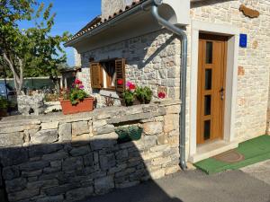 uma casa de pedra com uma janela e flores nela em Casa Borgo em Bale