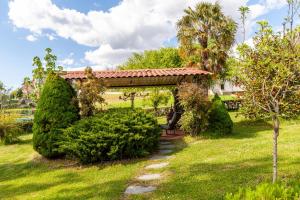 un jardín con una pérgola con una persona sentada debajo en Casa vacanze La Capannina, en Pieve Fosciana