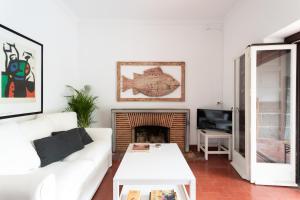a living room with a white couch and a fireplace at Villa Jacarandá in Cascais