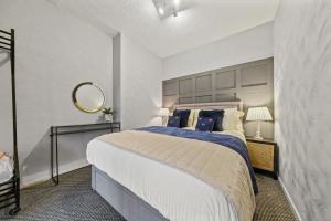 Holywell Apartment - Luxury One Bedroom Apartment في هوليويل: غرفة نوم بسرير كبير ومرآة