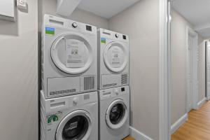 two washing machines are stacked in a laundry room at London's boutique studio in London