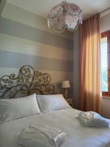 a bedroom with a large white bed with a chandelier at Hotel Atlantico in Castiglioncello