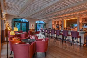 un restaurante con sillas rojas y un bar en Coquillade Provence en Gargas