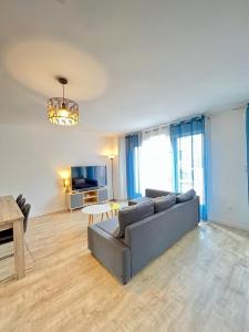 a living room with a couch and a table at Amsterdam - Bel appartement in Bezannes-les-Reims