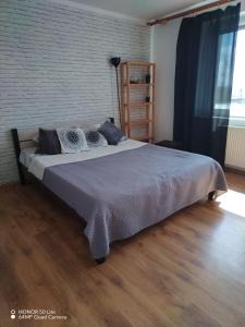 - un grand lit dans une chambre dotée de parquet dans l'établissement Wygodny apartament blisko morza, à Łokciowe