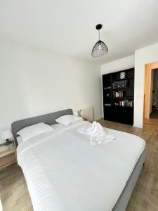 a large white bed in a bedroom with a lamp at Amsterdam - Bel appartement in Bezannes-les-Reims