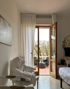 una camera da letto con una sedia, un letto e una porta scorrevole in vetro di Hotel Atlantico a Castiglioncello