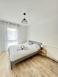 a bedroom with a large bed in a white room at Amsterdam - Bel appartement in Bezannes-les-Reims