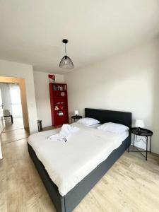 a bedroom with a large bed with white sheets at Amsterdam - Bel appartement in Bezannes-les-Reims