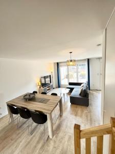 a living room with a table and a couch at Amsterdam - Bel appartement in Bezannes-les-Reims