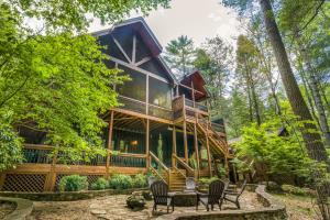 ein Haus im Wald mit einer umlaufenden Veranda in der Unterkunft Le Hermitage in Ellijay