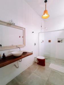 a bathroom with a sink and a mirror and a shower at CASA MANGARITO in Ubatuba